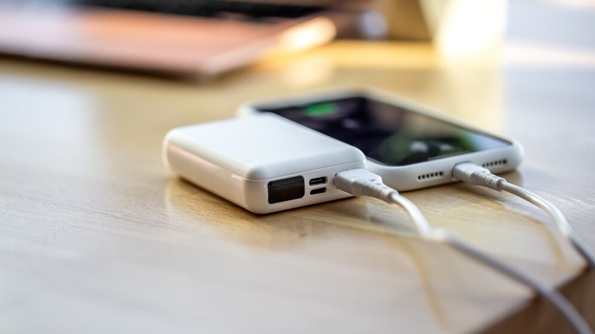 smartphone is charged from a small white power bank with USB-C cable