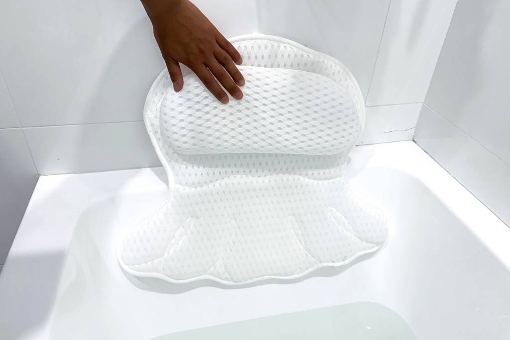 Close-up of durable bath pillow materials with suction straps on a modern acrylic tub.